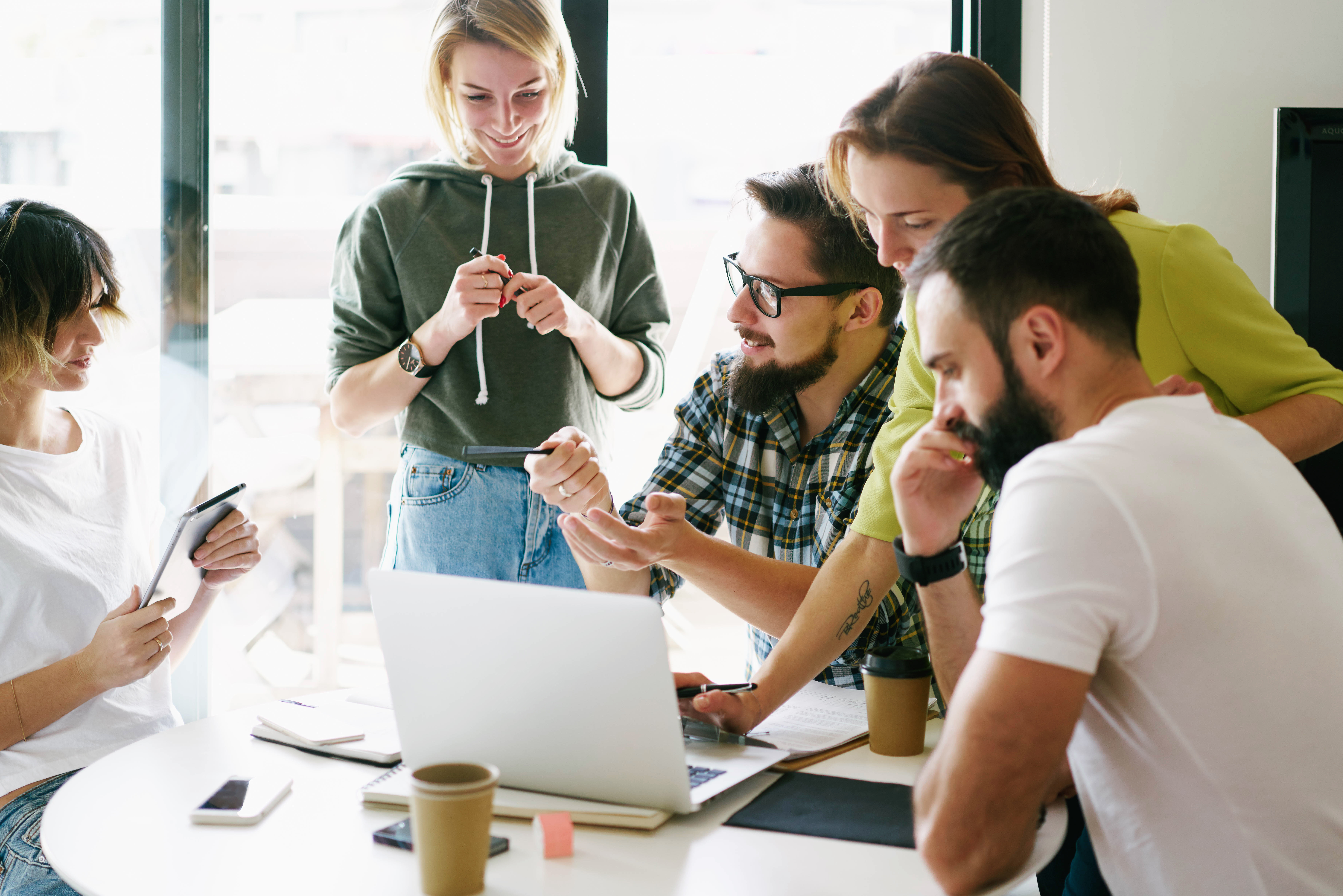 Digital designers are discussing new concept during the meeting with the colleagues. Business people are brainstorming on a new business project. Group of hipsters are thinking on the new start up.